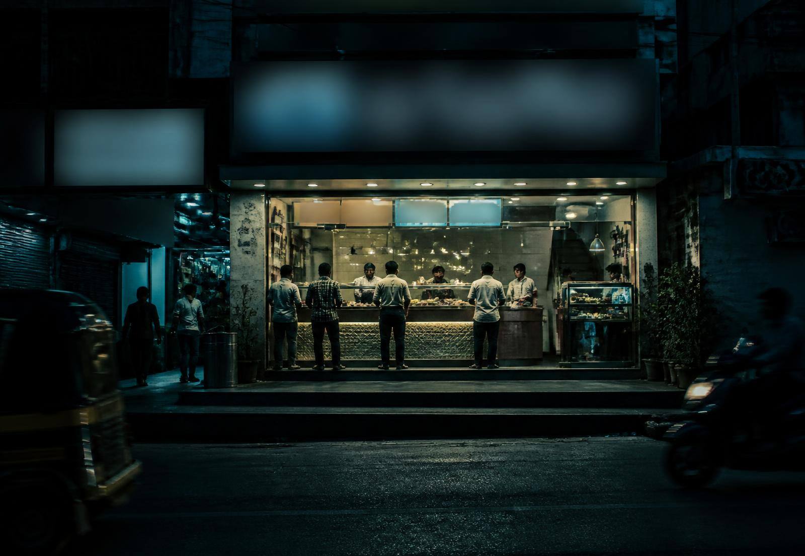 An Indian high-street quick-service restaurant unit in the evening with customers at the counter